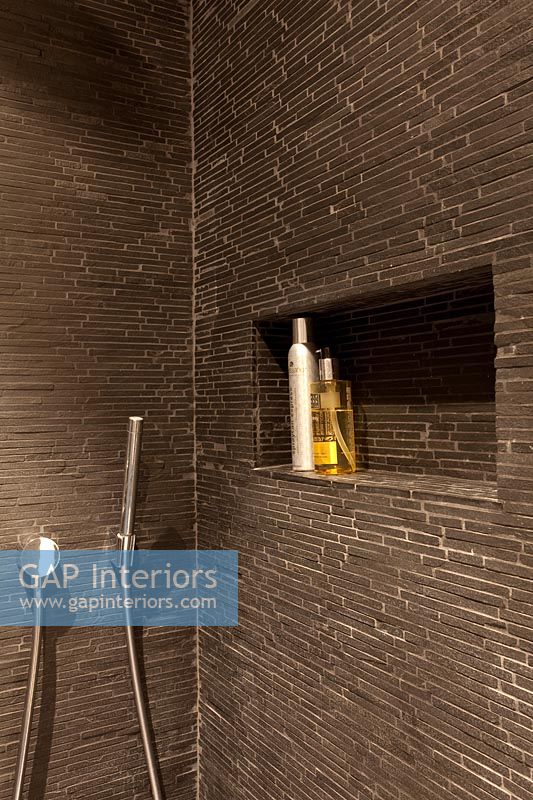 Brown shower cubicle alcove with toiletries 
