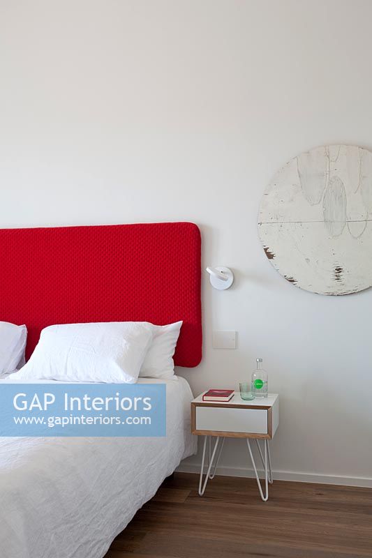 White bedroom with bright red headboard 