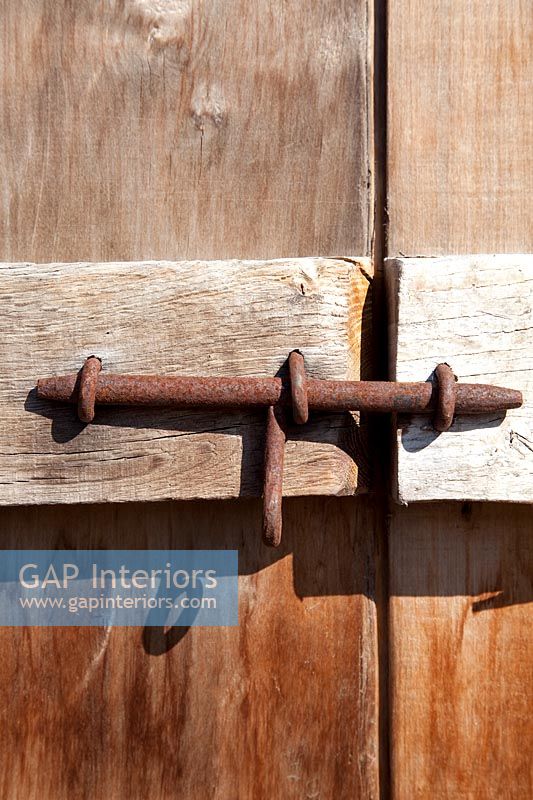 Rusted bolt on wooden door 
