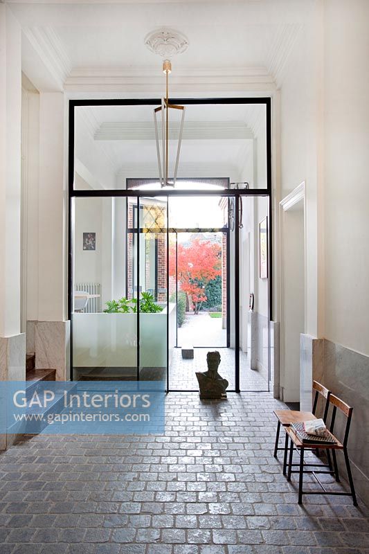 Classic hallway with glazed internal doors seats and sculpture 