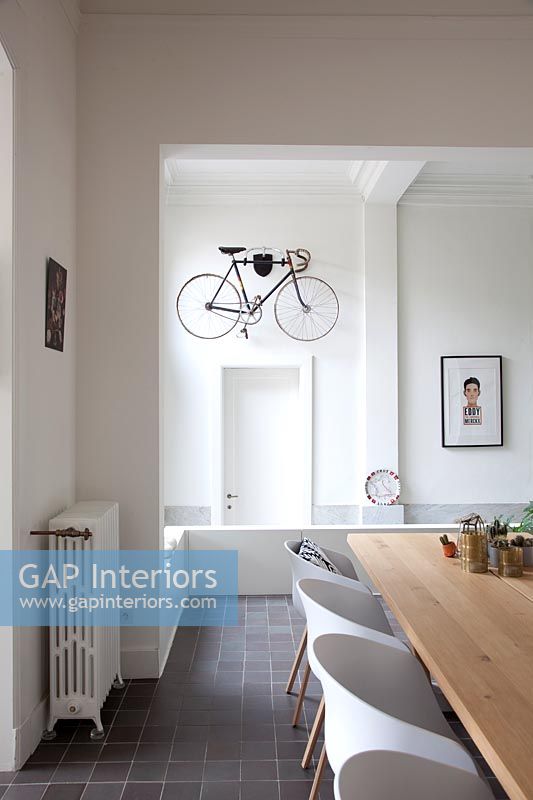 Modern dining room with view to hallway and wall mounted bicycle 
