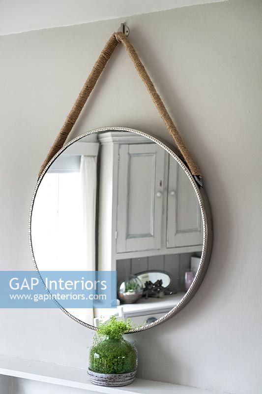 Circular mirror suspended by rope 