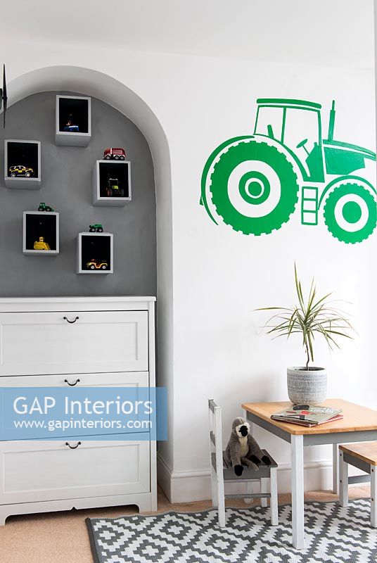 Chest of drawers in alcove and tractor mural in childrens room 