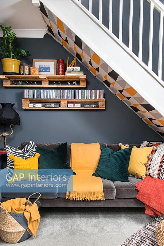 Sofa under staircase in colourful modern open plan sitting room