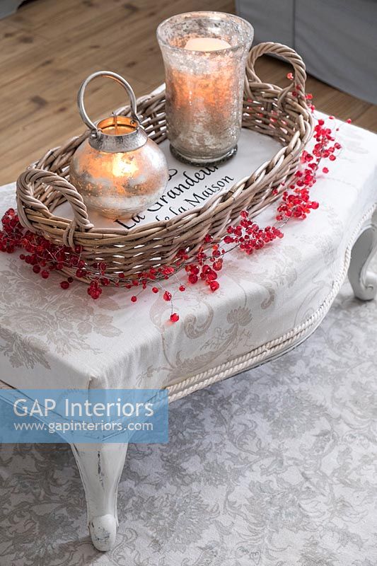 Candles in holders on footstool 