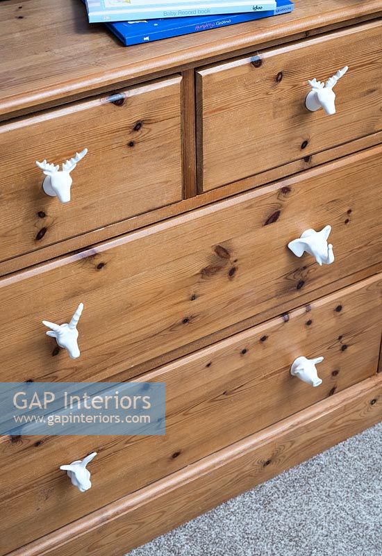 Decorative knobs on wooden chest of drawers  