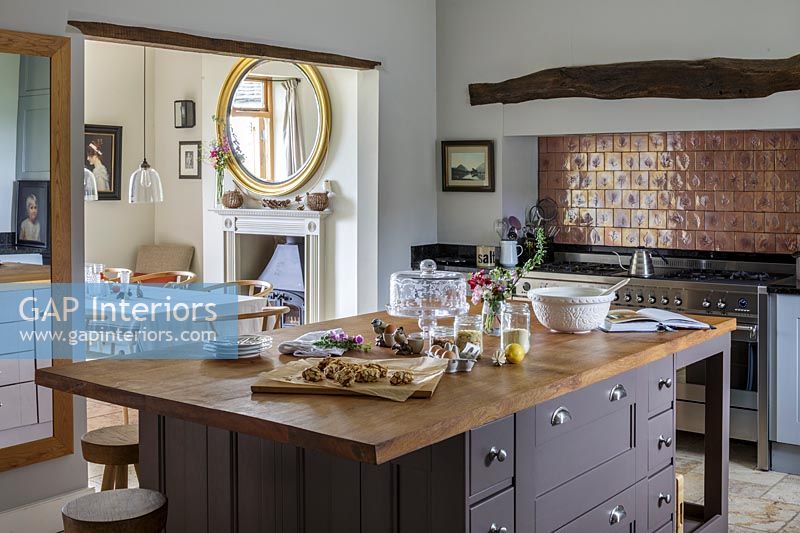 Modern country kitchen with copper splash backs above range cooker 