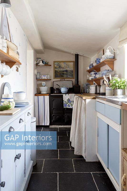 Galley kitchen with blue cabinets 