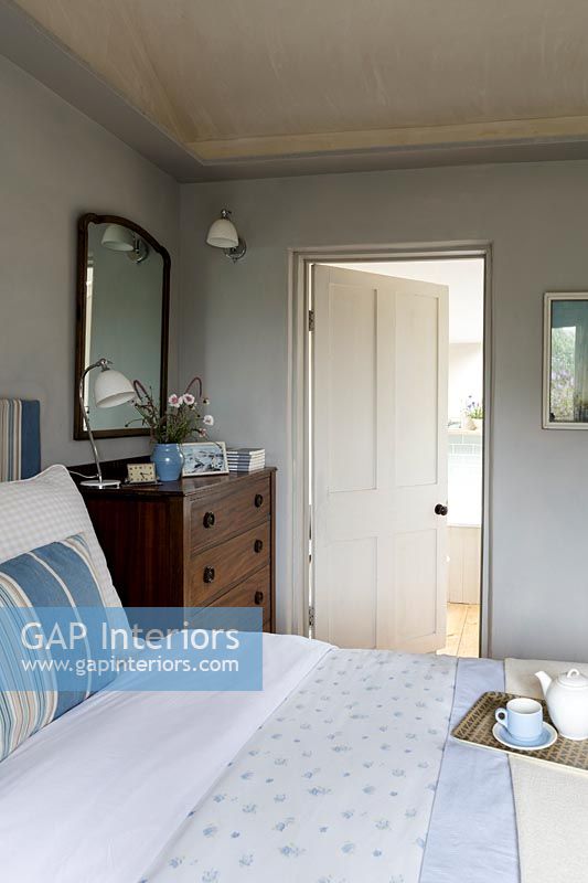 Country cottage bedroom with open internal door to bathroom 