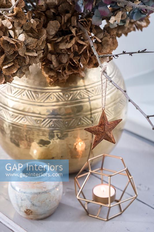 Copper star on gold pot of dried flowers 