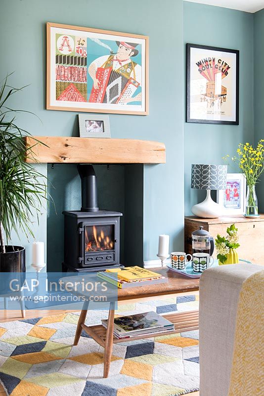 Wood burning stove in modern living room with teal painted walls 