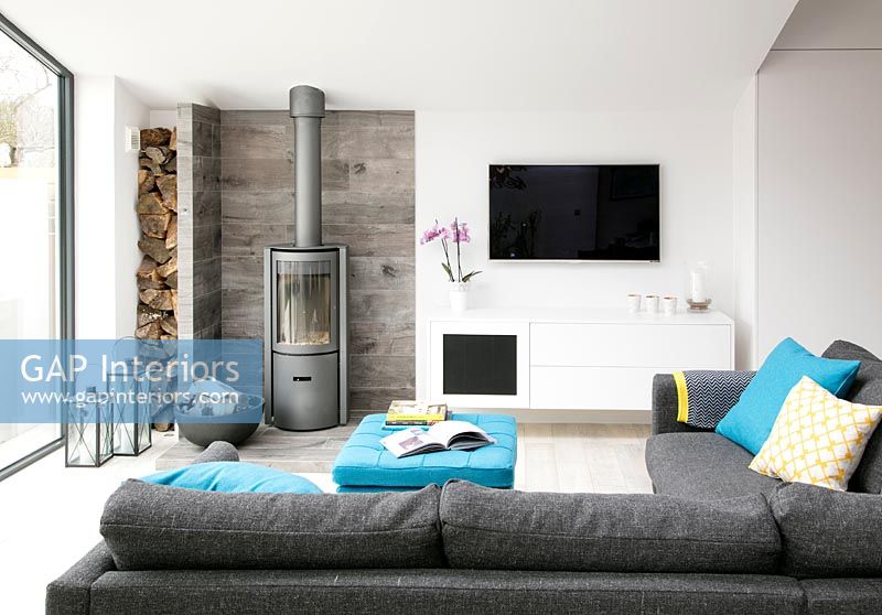 Modern living room with log burning stove and wall mounted television 