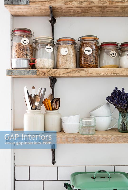 Storage jars on wooden kitchen shelves 