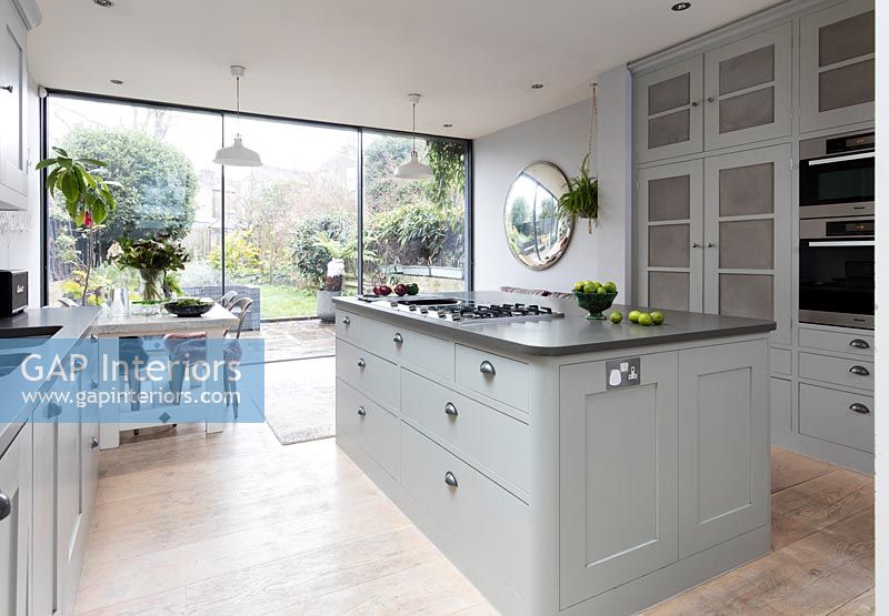 Pale grey contemporary kitchen with glazed doors to the garden 