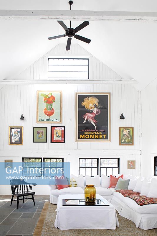 Display of colourful artwork and ceiling fan in modern country living room 