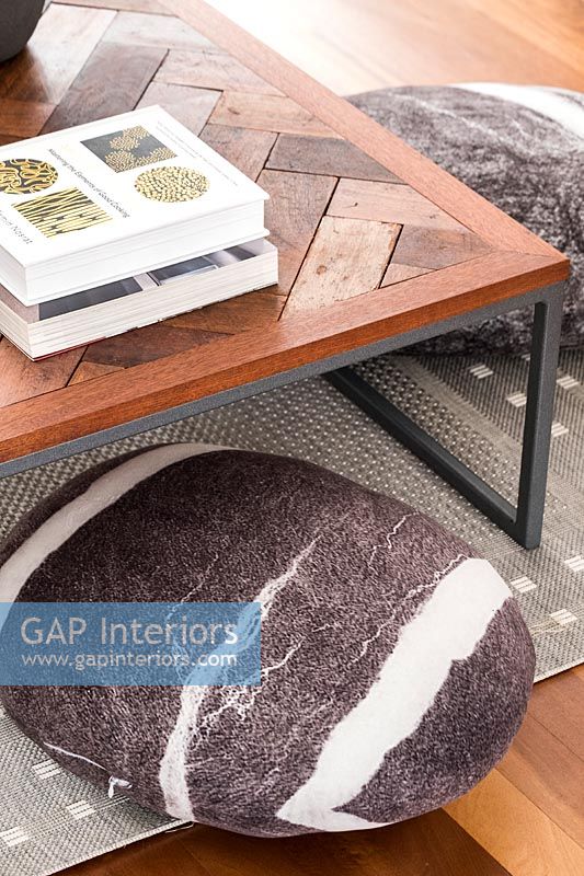 Detail of wooden coffee table and floor cushion 