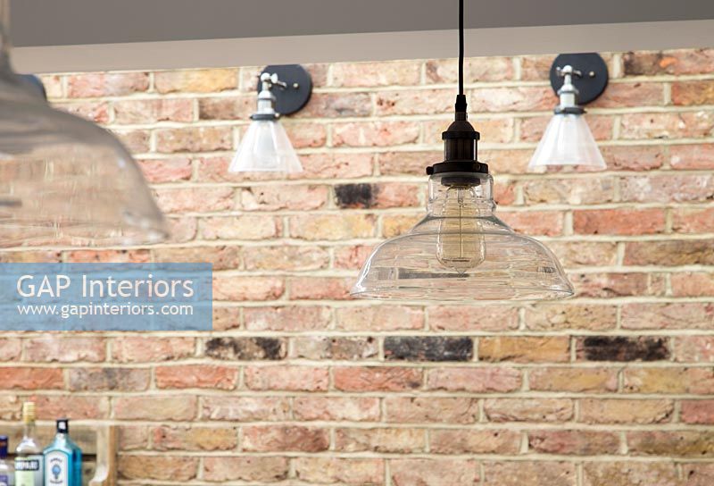 Pendant and wall lights on exposed brick wall 