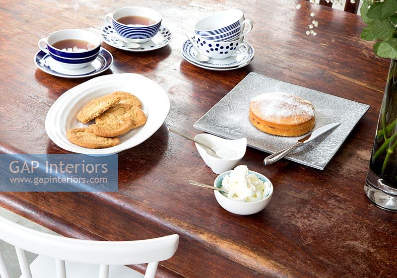 Tea and cake on wooden dining table 