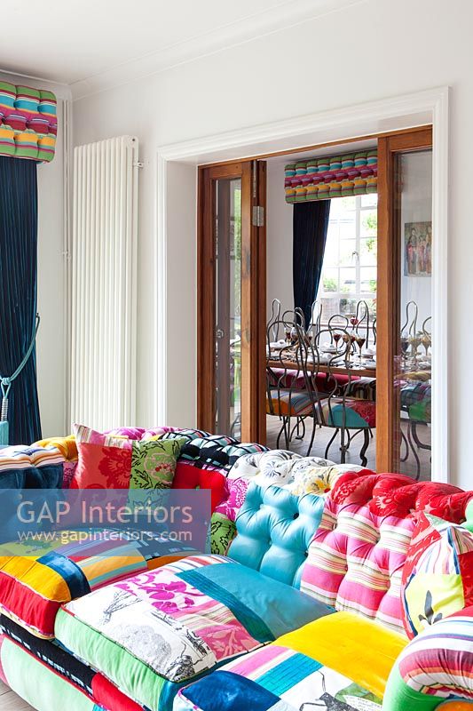 Colourful eclectic living room with internal folding doors to dining room 