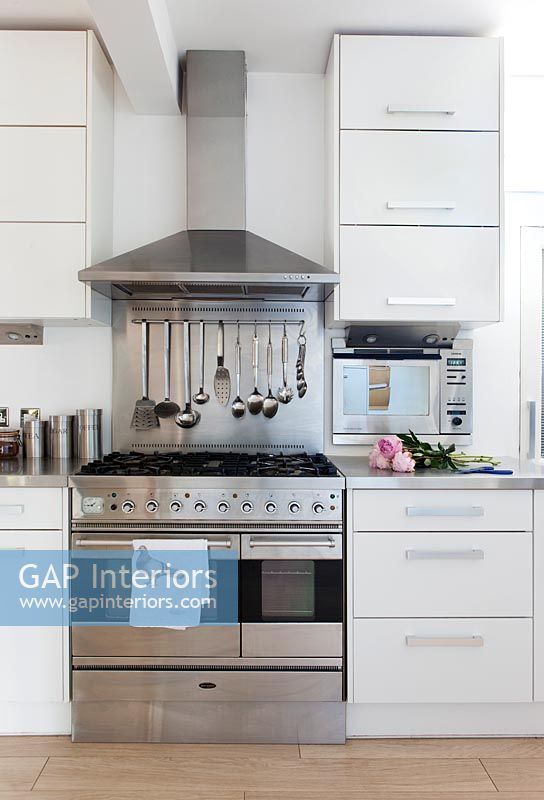 White kitchen with stainless steel appliances and worktops 