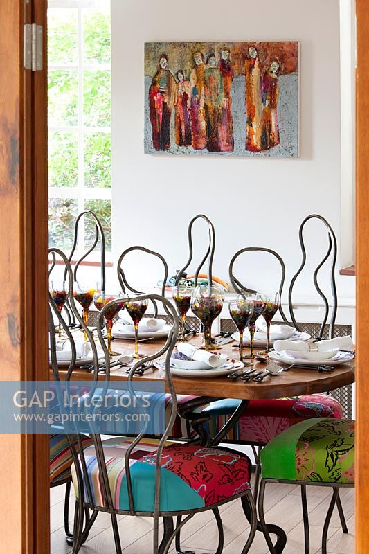 Colourful chairs in eclectic dining room 