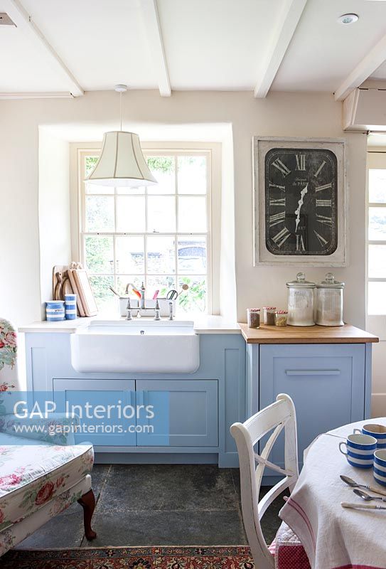 Blue and white kitchen with large wall clock 