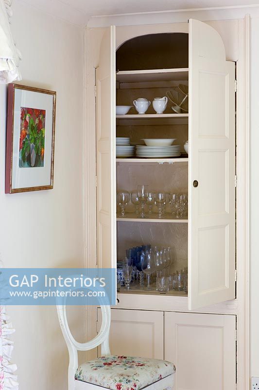 Crockery and glassware in built in cabinet in dining room 