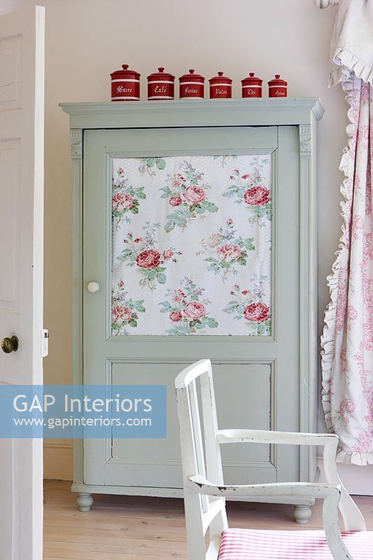 Floral fabric lined cabinet in country dining room 