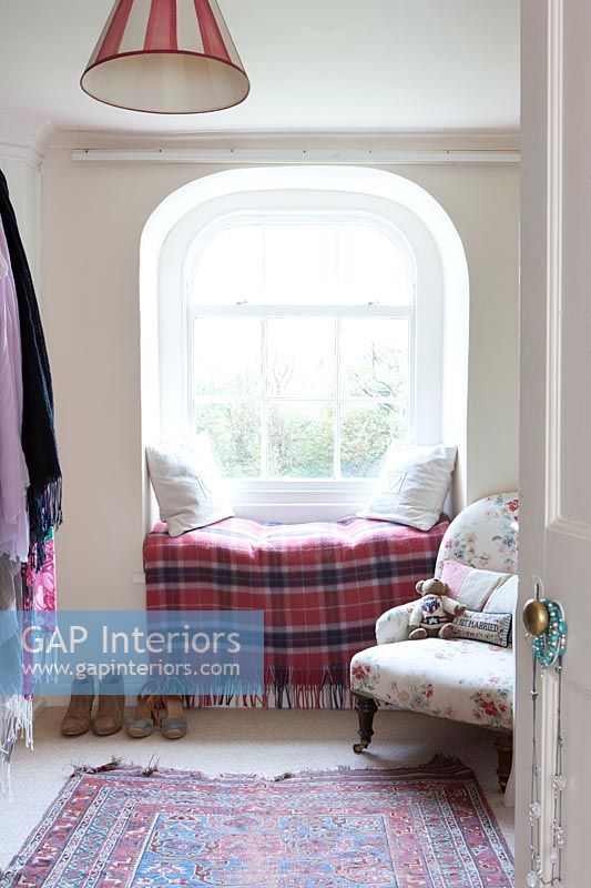 Checked blanket and cushions in alcove window seat 