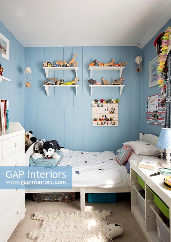 Blue painted wooden paneled walls in childrens bedroom 