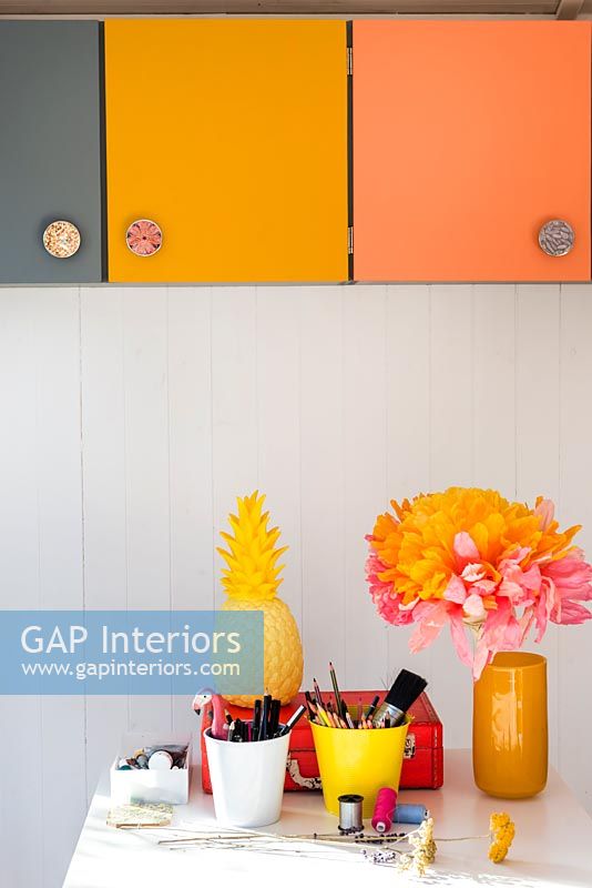 Colourful cupboards and accessories on desk in home office 
