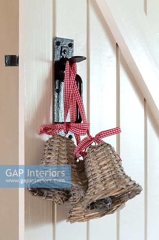Christmas decorations - wicker bells with ribbon on country door handle 