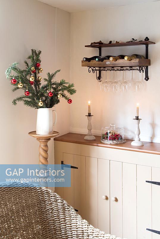 Wine rack and glasses above country sideboard at Christmas