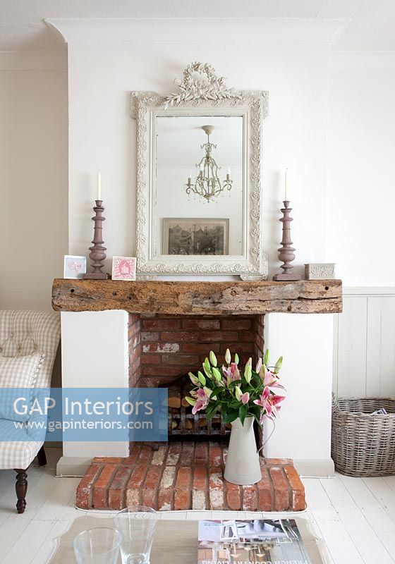 Brick fireplace with exposed wooden beam as mantelpiece 