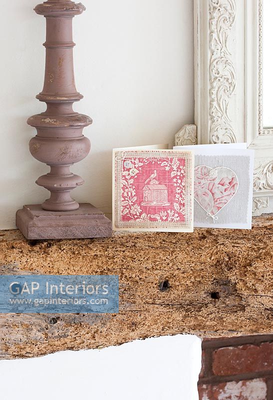 Pink greeting cards on rustic wooden mantelpiece 