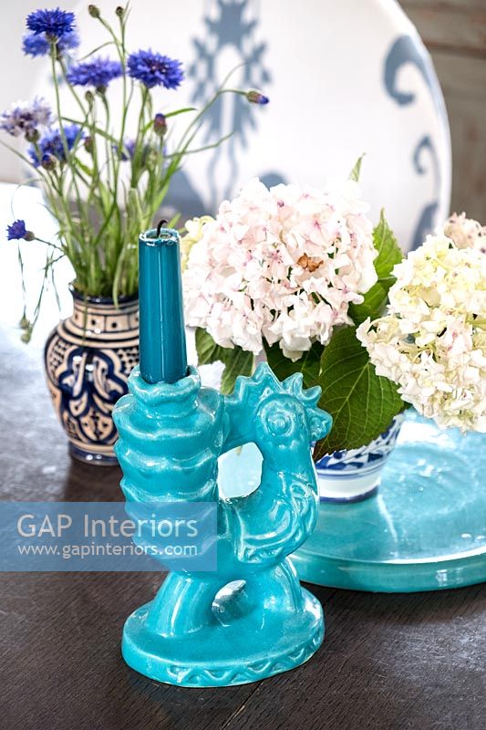 Candlestick and flower arrangements in ceramic pots 