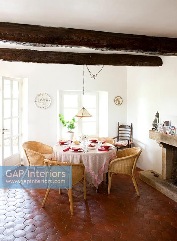 Wicker chairs around table in country dining room 
