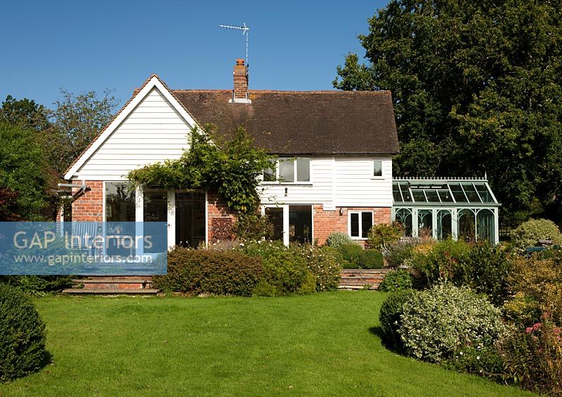 Country house exterior with small classic conservatory 