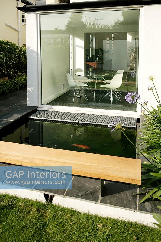 Fish in modern pond with large window to dining room 