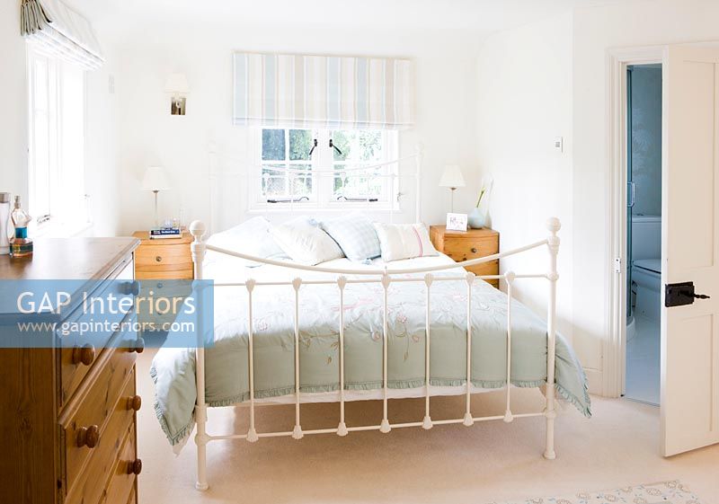 Modern country bedroom with large metal framed bed 