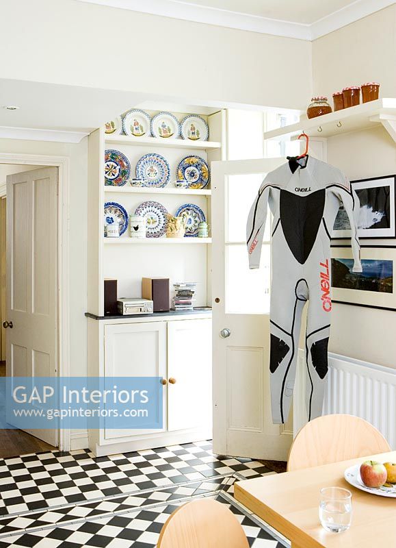 Wet suit hanging on kitchen-diner door 