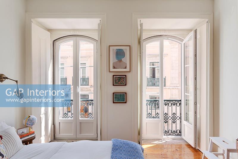 Open French windows in classic bedroom with balcony 