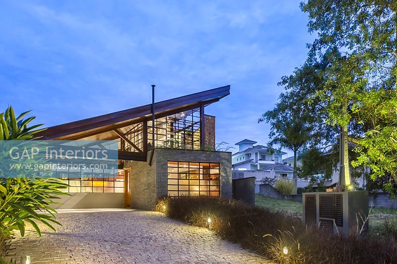 Contemporary house with pitched roof illuminated at night - Brazil 