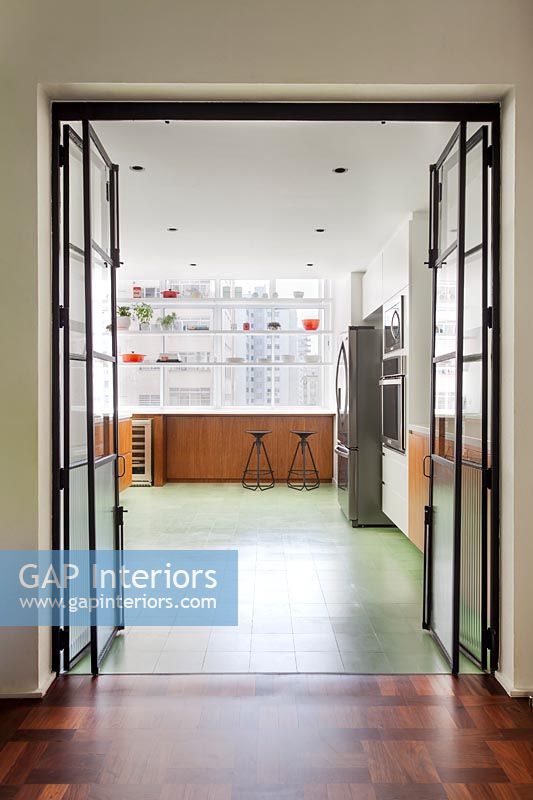 View through bi-fold internal doors to contemporary industrial kitchen