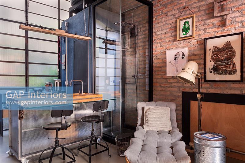 Modern industrial kitchen with exposed brick wall and shower cubicle 