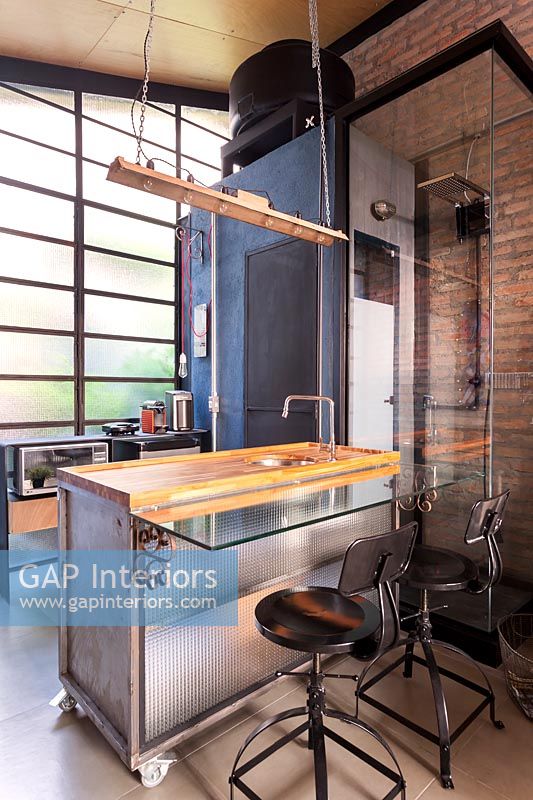 Modern industrial kitchen with exposed brick wall and shower cubicle 