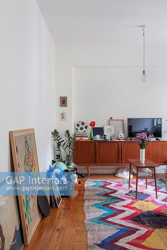 Vintage sideboard in modern living room with patterned rug 