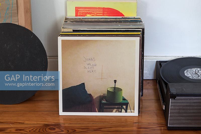 Vinyl records on floor next to turntable 
