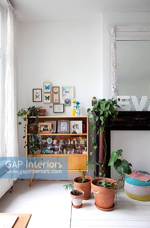 Vintage cabinet surrounded by potted plants 