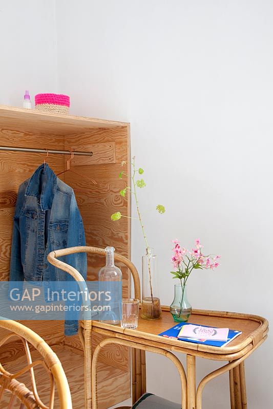 Wooden cabinet with clothes rail and bamboo drinks trolley 